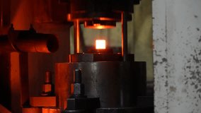Glowing hot metal piece secured on a fixture with threaded rods and bolts. High-temperature industrial process used in forging, heat treatment, or precision metalworking under dim lighting. - Powered by Shutterstock - Get 15% off with code: PIKWIZARD15