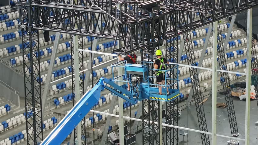 Music concert stage set up buildup construction. stadium football pitch being prepared to host a music concert. sports stadium as technicians set up the stage for the live music event.