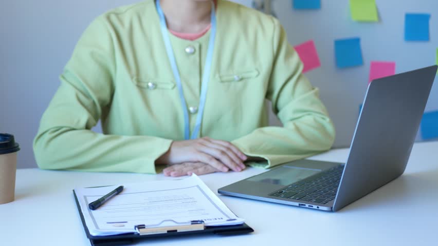 Young businesswoman holds a resume and evaluates it. Views the personal history of job applicants. Recruitment concept.