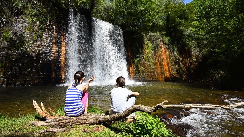Family kids joy enjoy having fun near colorful waterfall in forest