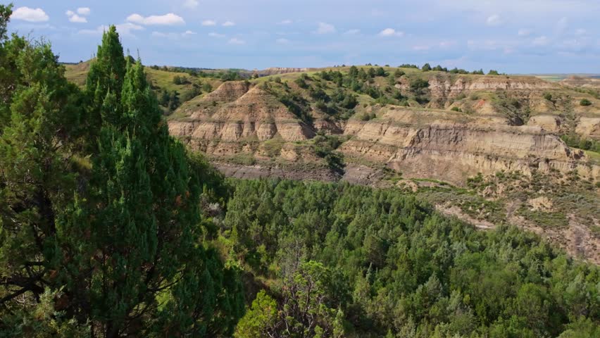 A sweeping panoramic view captures the dramatic landscapes along the Caprock Coulee Trail at Theodore Roosevelt National Park