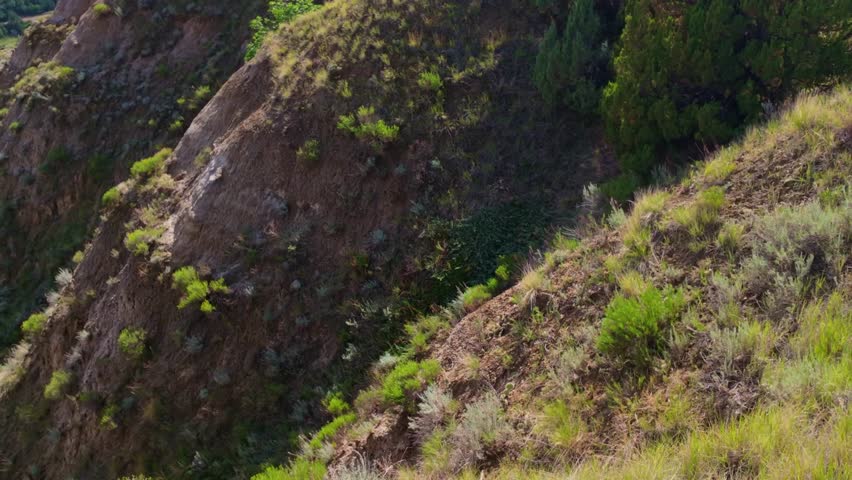 A sweeping panoramic view captures the dramatic landscapes along the Caprock Coulee Trail at Theodore Roosevelt National Park