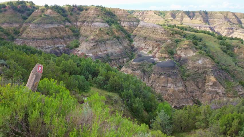 A sweeping panoramic view captures the dramatic landscapes along the Caprock Coulee Trail at Theodore Roosevelt National Park
