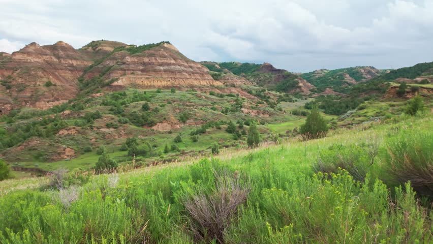 An expansive scenic overview captures the rugged mountains and diverse landscape of the North Side of Theodore Roosevelt National Park