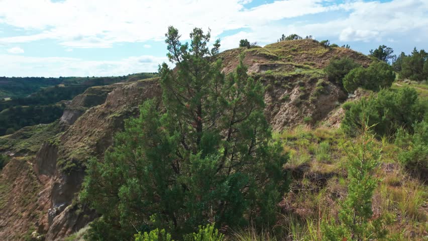 A sweeping panoramic view captures the dramatic landscapes along the Caprock Coulee Trail at Theodore Roosevelt National Park