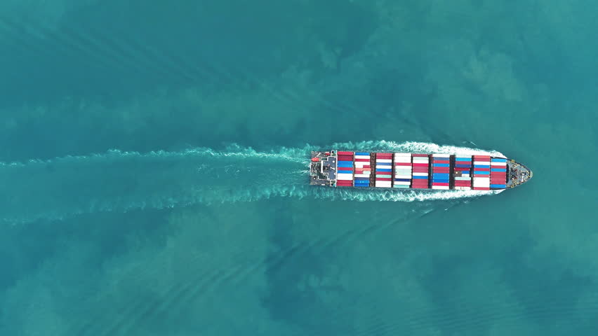 Aerial of cargo ship carrying container and running verry fast for export cargo from cargo yard port to other ocean concept smart freight shipping ship top view