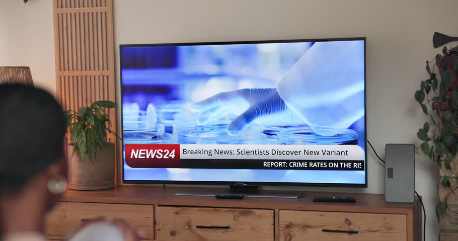 Person, home and watching tv screen for breaking news with virus, pandemic and headlines in lounge. Television show, broadcast and healthcare information for program, report and medical research