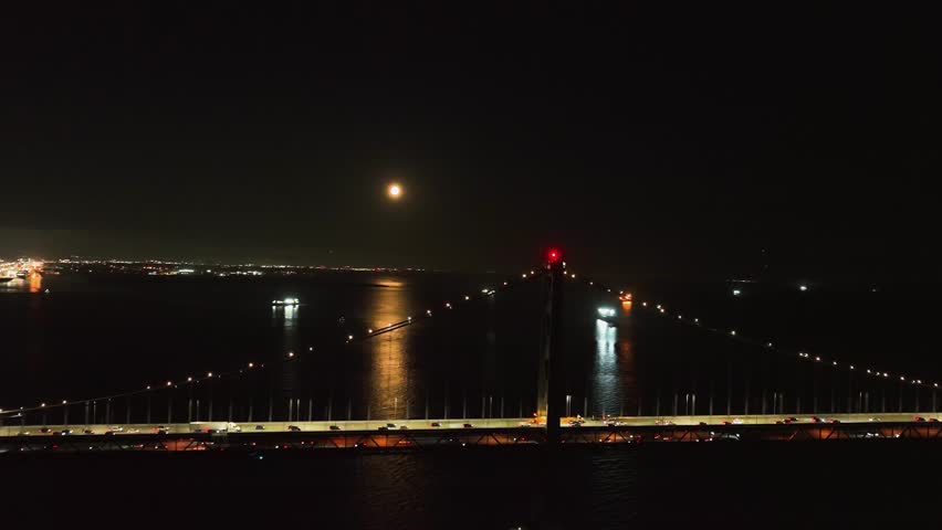 Drone rotating in front of the Oakland bay bridge, full moon in San Francisco