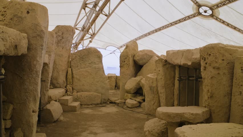 Stone circular room in Ħaġar Qim Archaeological Site with Filfla island in the background