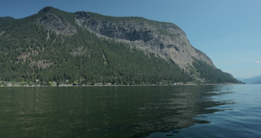 Scenic view of Bastion mountain side from a boat in the middle of Lake Shuswap near Salmon Arm, British Columbia, Canada.