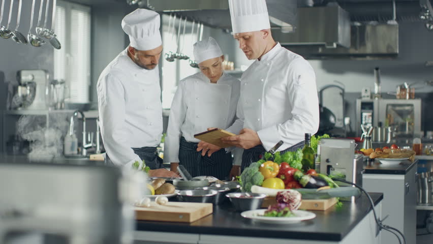 Three White Chefs collaborate in a Modern Kitchen, Using a Digital Tablet to Browse Online Menus and Order Fresh Ingredients, Culinary Creativity With Innovative Ecommerce Technology for Meal Planning