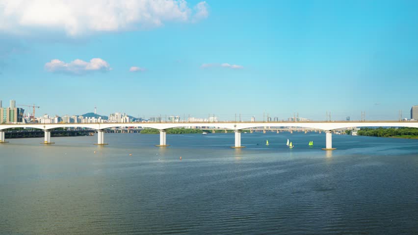 Two subway trains traveling in opposite directions meet in the middle of the Dangsan Railway Bridge over the Hangang River, with the iconic Namsan Tower and Seoul skyline in background
