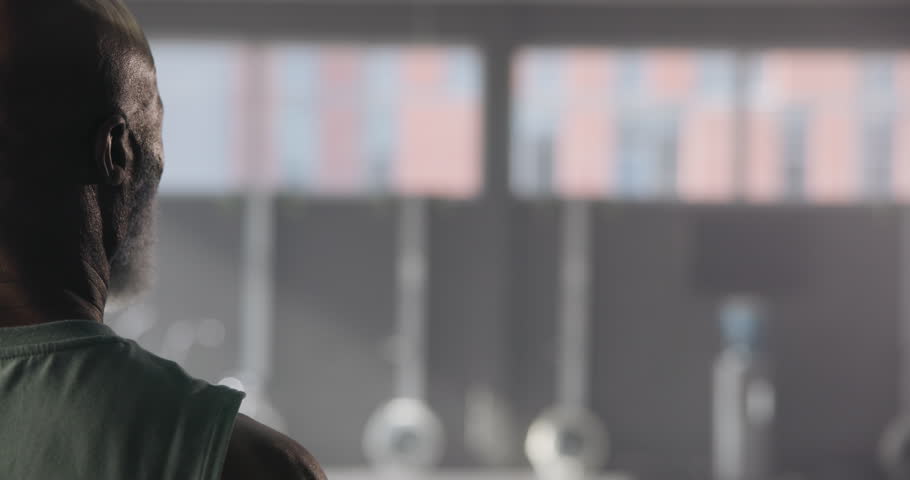 Fitness, black man and back view of flexing biceps, bodybuilder and exercise in gym. Mature person, training and muscle goals for power, strength and pride for wellness and workout for progress