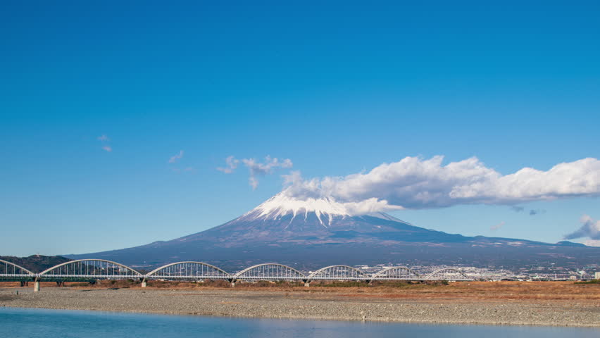 Timelapse clouds rolling over Mount Fuji and the Fujikawa bridge, Shizuoka, Japan 