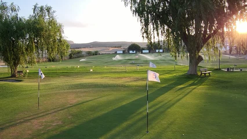 Golf course practice area at sunset. Range practice area golf club. Green, flags and golf holes. practice facility golf area. Granada. Spain. - Powered by Shutterstock - Get 15% off with code: PIKWIZARD15