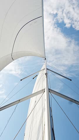 White sails filled with wind, seen from the bow of a sailing yacht near Croatia. Freedom, clean energy, adventure and mindful travel on the open sea. High quality 4k footage