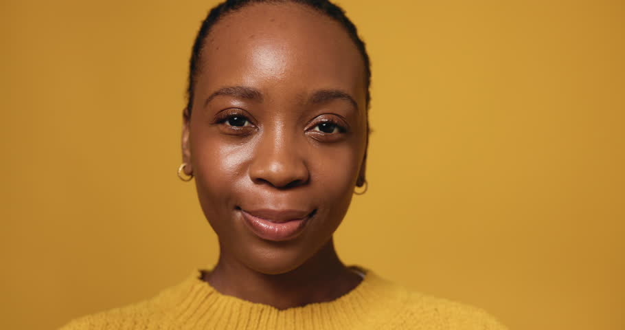 Face, African woman and happy in studio for funny joke, comic story and stress free. Portrait, female person and smile with laugh, positive attitude and expression with good mood on yellow background
