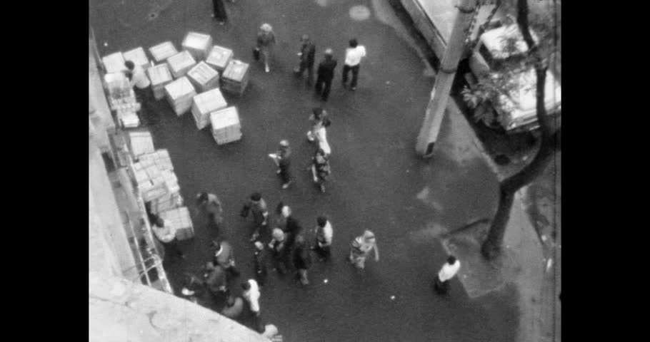 People stand in line at a store where scarce goods have been delivered. Boxes are unloaded near the store. Archival video, 1970s, Kyiv, Ukraine.