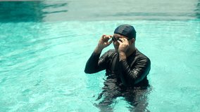 Relax moment of man in swim cap and rash guard adjusts their swimming goggles ready to dive into the pool. Aquatic sports and a healthy active lifestyle perfect fitness and summer activities. - Powered by Shutterstock - Get 15% off with code: PIKWIZARD15
