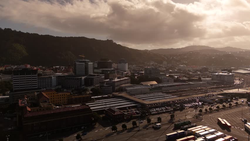 Port area of Wellington with boats and housing area in background. Sunset time. Aerial wide shot. Residential apartment blocks in city of New Zealand. Dusk scene.
