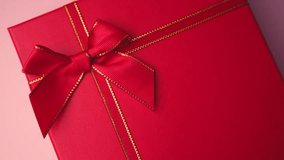 A classic red gift box is adorned with a festive red ribbon bow and shimmering gold trim, ready for any joyous occasion. - Powered by Shutterstock - Get 15% off with code: PIKWIZARD15