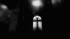Black and white stained glass cross window in shadowed church interior with dramatic light, evoking timeless Christian heritage and solemn spiritual reflection - Powered by Shutterstock - Get 15% off with code: PIKWIZARD15