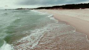 gentle waves reach wide empty beach near forest and distant town - Powered by Shutterstock - Get 15% off with code: PIKWIZARD15