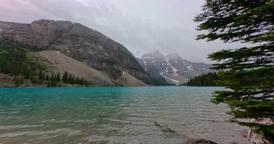 Lake side view of the beautiful azure blue waters of Moriane Lake in Banff National Park in Alberta Canada.