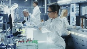Medical Research Scientist Opening Refrigerator Box Takes Out Petri Dish with Frozen Samples and Examines it. He Works in a Busy Modern Laboratory Center. - Powered by Shutterstock - Get 15% off with code: PIKWIZARD15