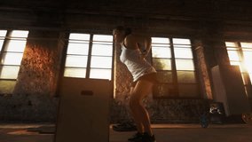 Fit Woman Performs Box Jumps in an Industrial Gym With Stone Walls, Large Windows, and Sunlight Streaming In, Focusing on Lower Body Strength, Agility, Cardio Exercise. - Powered by Shutterstock - Get 15% off with code: PIKWIZARD15