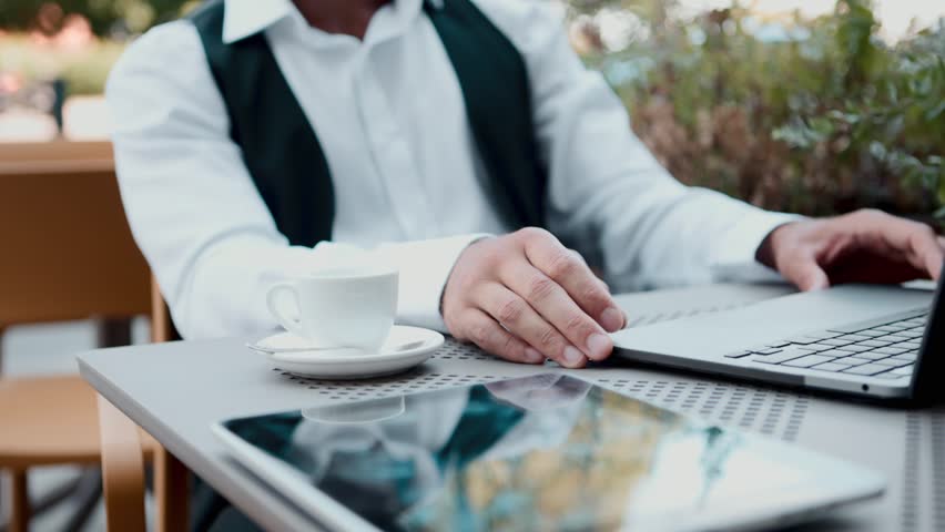 Business man drinking coffee at the break from working on laptop. Concept of mindful lifestyle, modern masculinity, business breaks, and balance in digital work culture.