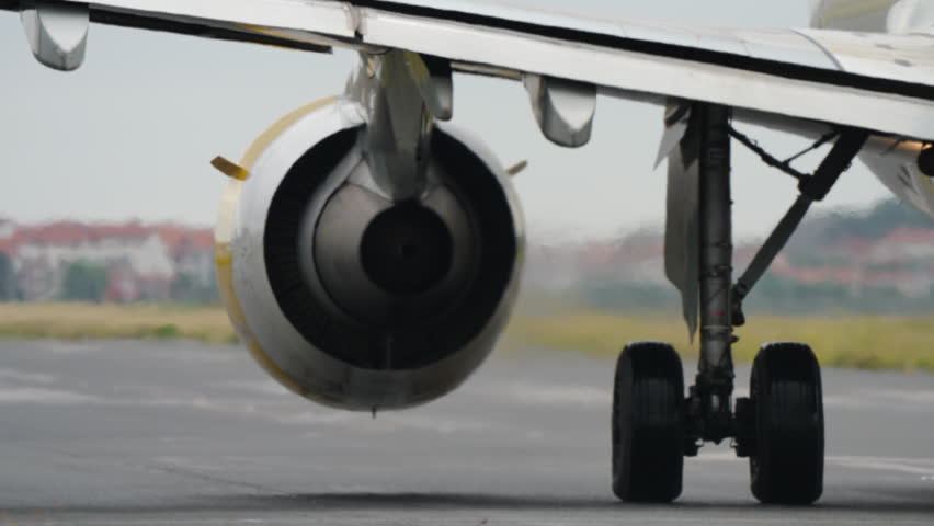 Close-up view of aircraft engine and landing gear on runway, everything is ready for take off