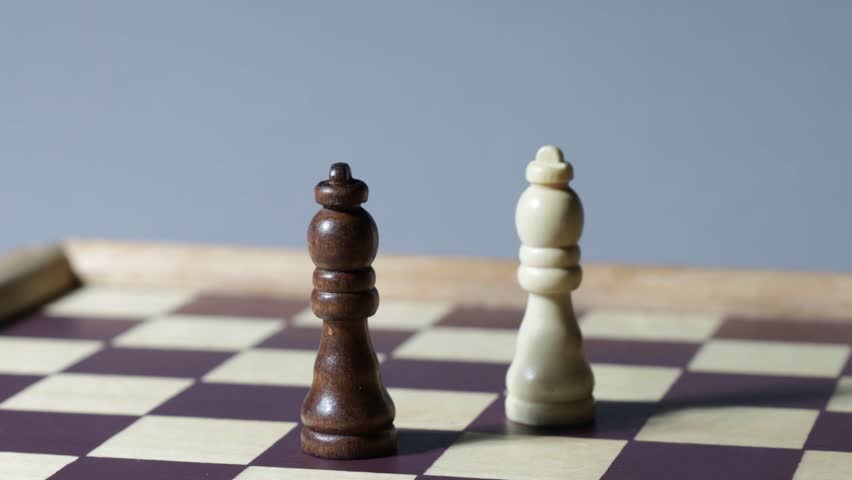Cinematic rotating shot of black and white queen on a chessboard.