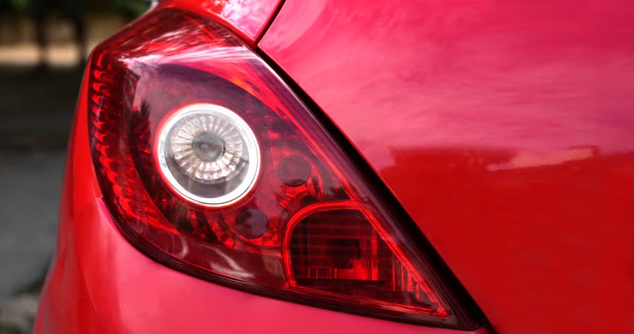 Seamless loop animation slideshow of car headlight brake light urban street background backdrop. Close up of a car.