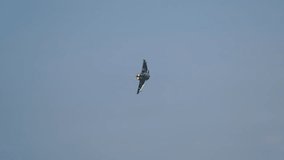 Military jet fighter flying at angle above lush green hills and residential area - Powered by Shutterstock - Get 15% off with code: PIKWIZARD15