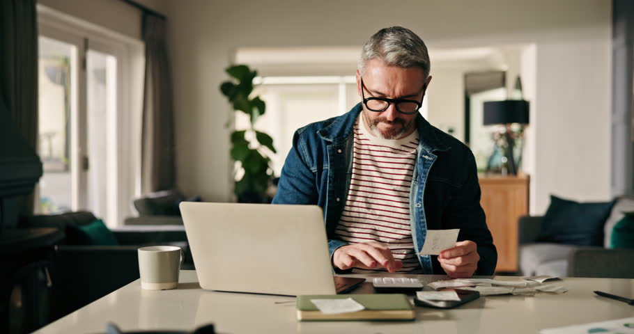 Mature man, finance and laptop with receipts in home for budget calculation, expenses or bills. Male person, calculator and audit with papers or slips for financial planning or tax return in house