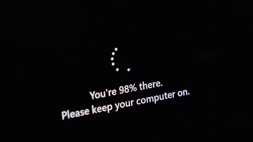 Close-up view of a dark computer monitor displaying You're 98% there text, symbolizing the final stages of a critical software update or system boot