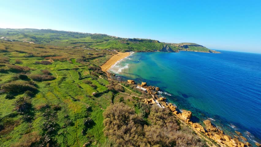FPV drone view of Ramla bay on Gozo island, Malta. Waves, sea