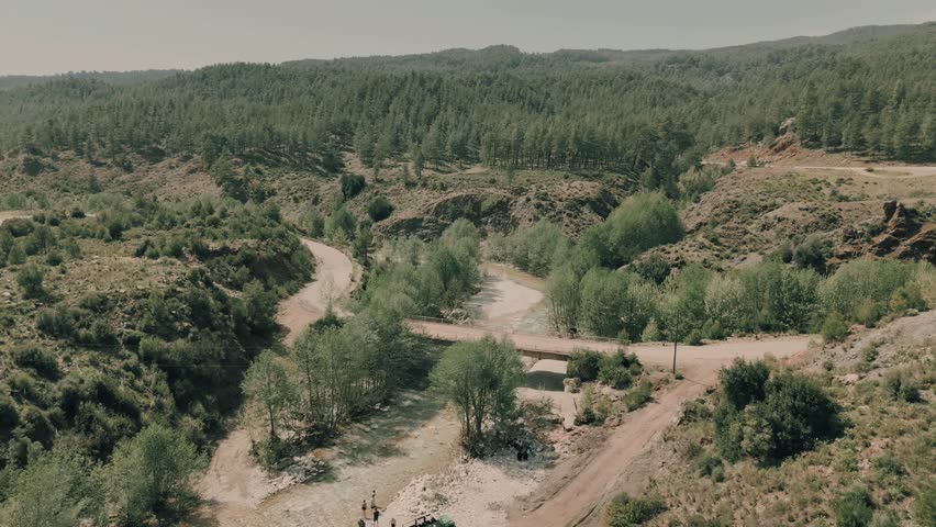 A Drone shot over Haspinar serene water stream, surrounded by trees and tranquil mountainous terrain