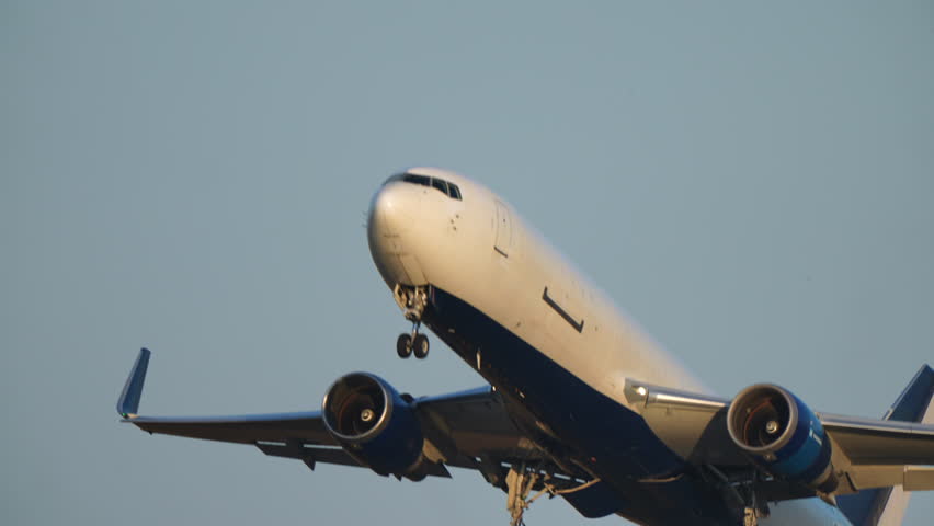 Commercial jet taking off with gear doors open and landing gear folding into fuselage mid-flight