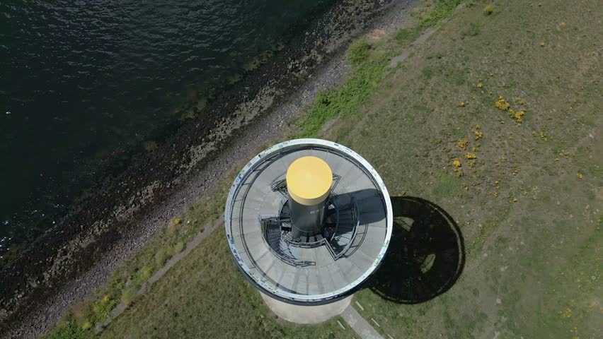 A drone shot of a 22-meter-high lookout tower with a spiral staircase located in the industrial port area of Rotterdam