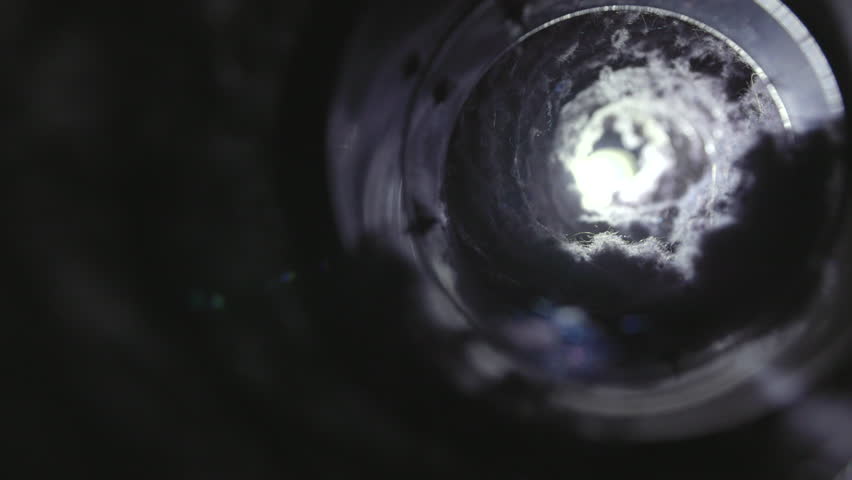 Close-up image of lint buildup inside a dryer vent, highlighting a common household fire hazard. The photo shows accumulated dust, fibers, and debris in the vent pipe, emphasizing the importance of re