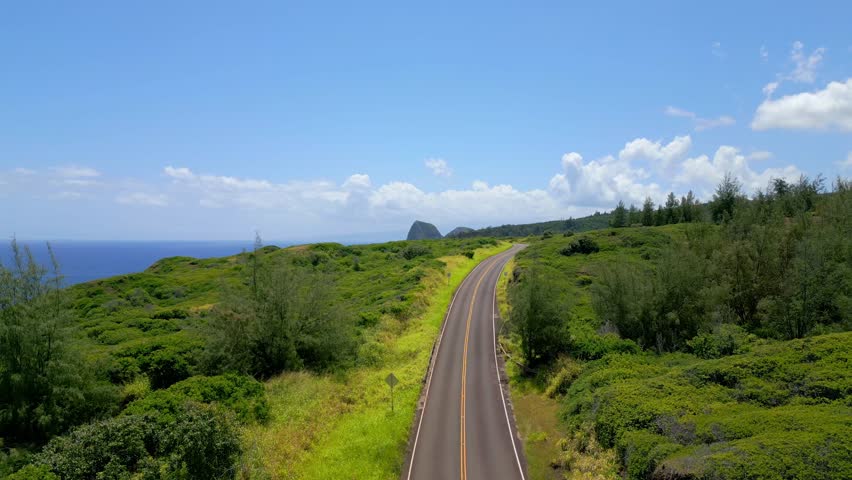 Aerial View of the Empty Kahekili Highway Leading Towards the Iconic Puʻu Koaʻe Peak on the Scenic Coastline of West Maui, Hawaii