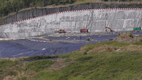 Modern eco-friendly landfill: unloading and disposal of waste using heavy equipment. The soil is protected by a special tarpaulin and covered with polyethylene. Environmentally safe waste processing. - Powered by Shutterstock - Get 15% off with code: PIKWIZARD15