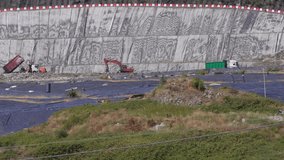 Modern eco-friendly landfill: unloading and disposal of waste using heavy equipment. The soil is protected by a special tarpaulin and covered with polyethylene. Environmentally safe waste processing. - Powered by Shutterstock - Get 15% off with code: PIKWIZARD15