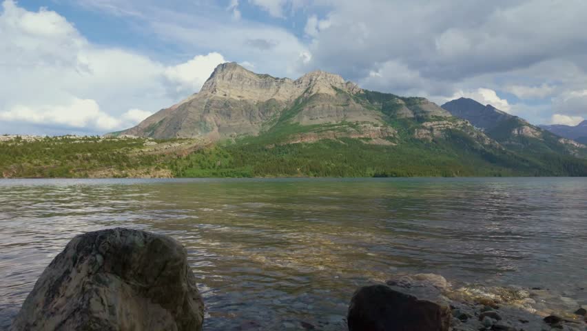 A scenic footage of mountain range and tranquil lake in Waterton Lakes National Park is in southern Alberta, Canada