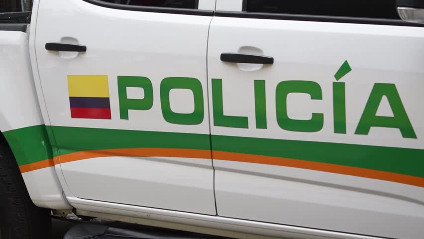 Colombian police vehicle in action on the street, Patrol car driving through urban area, Law enforcement transport in motion