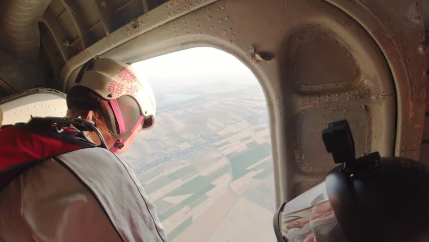 Woman jumps out of a plane with a parachute. Point of View. 