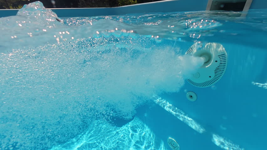 Swimming pool with active counterflow system creating strong water jets and bubbles underwater.