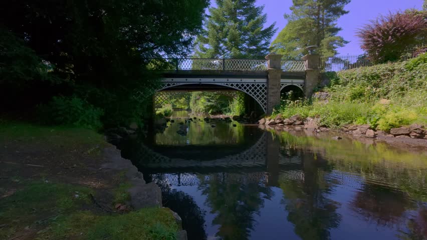 The ducks gliding calmly across the river in Pavilion Gardens, a historic Victorian-era public park in Buxton, Derbyshire, surrounded by lush greenery
